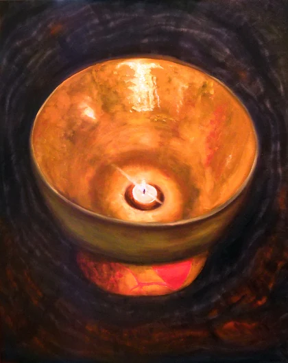 A small candle illuminates the golden interior of a hand-hammered singing bowl against a dark background.